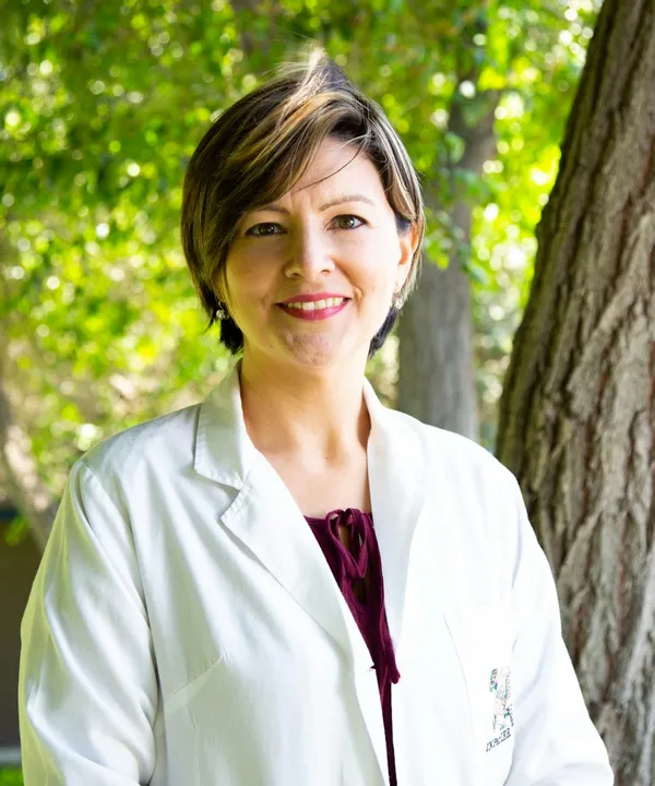 Dra. Camila Ferrer sonriendo en un parque